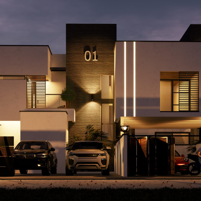 A night view of a four bedroom townhouse and cars parked out and a man on a motorcycle